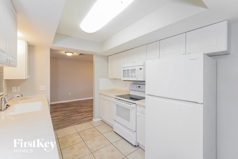 A kitchen with white appliances and a FirstKey Homes logo.