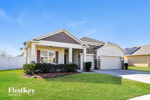 a house with a driveway and lawn in front of it