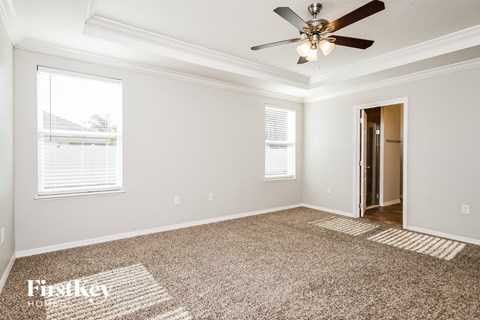 a living room with carpet and a ceiling fan