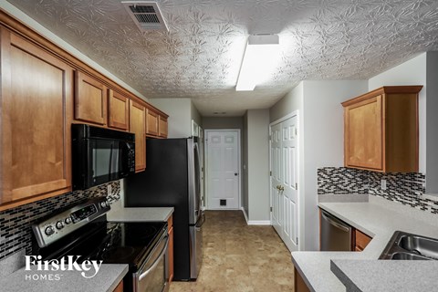 A kitchen with wooden cabinets and black appliances.