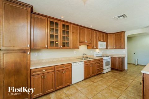A kitchen with wooden cabinets and appliances.