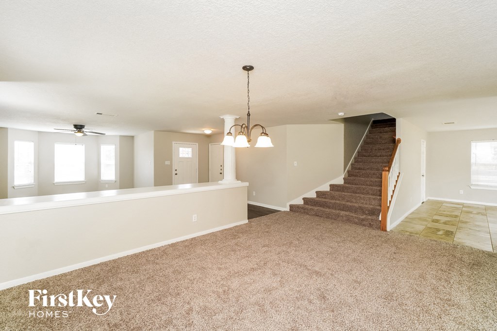the living room and dining room with the staircase to the second floor