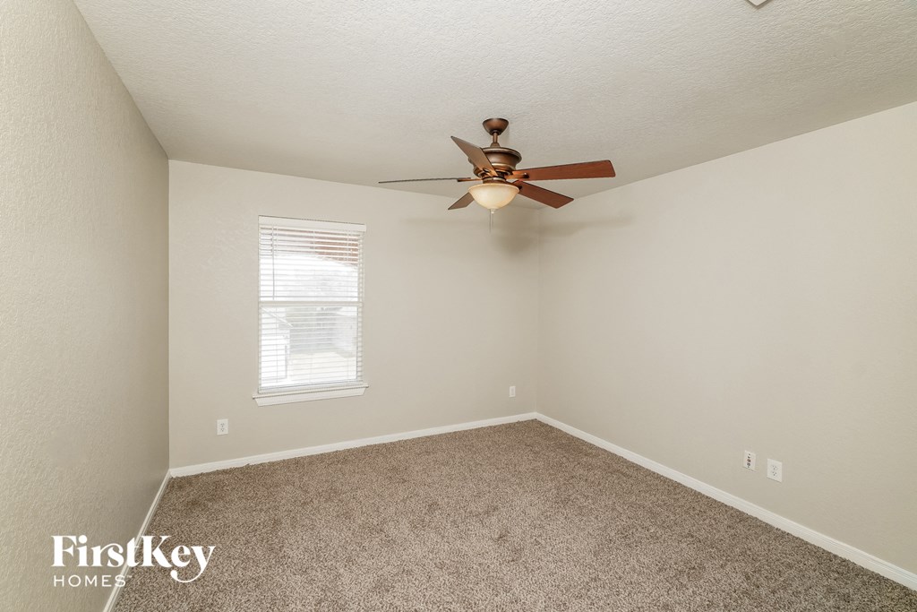 a bedroom with carpet and a ceiling fan