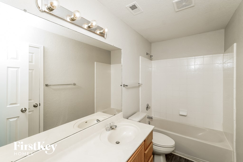 a white bathroom with a tub and a sink and a toilet