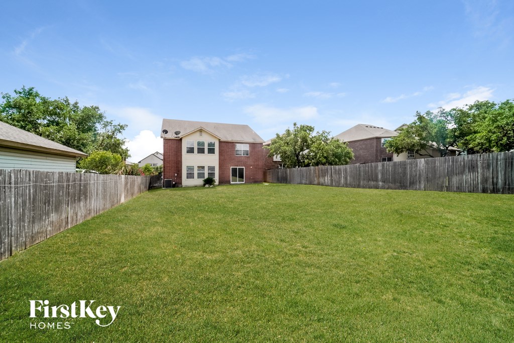 the backyard of a house with a yard and a fence