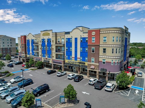 an aerial view of a parking lot in front of an apartment building