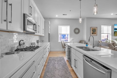 a kitchen with white cabinets and stainless steel appliances and a sink