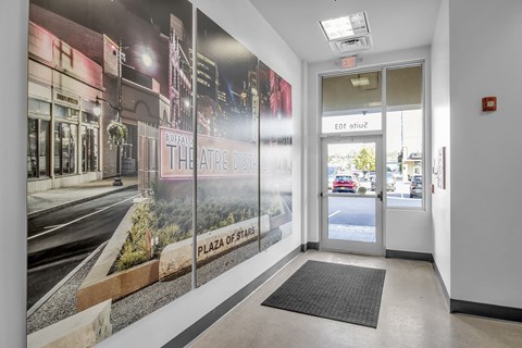 a lobby with a poster on the wall and a door
