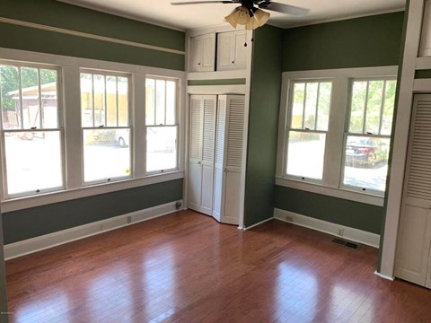a living room with a hard wood floor and green walls