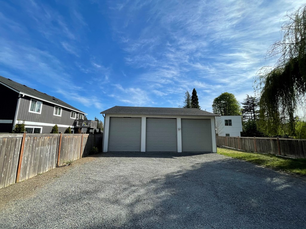 a garage and a house on a gravel driveway