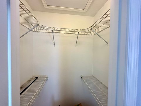Empty shelves in a white pantry.