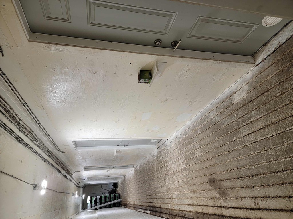a long hallway with a brick wall and a white ceiling