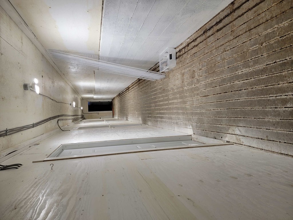 a large room with wooden floors and a brick wall
