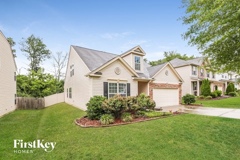 A house with a well-maintained lawn and a clear sky.