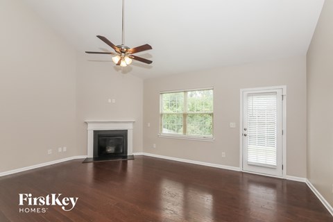 A spacious room with a fireplace and a ceiling fan.