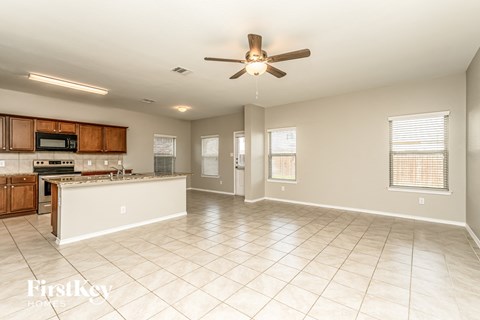an empty kitchen and living room with a ceiling fan