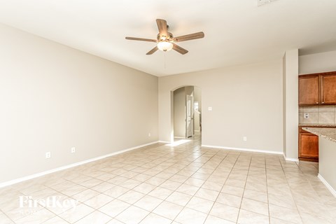 a clean and empty living room with a ceiling fan