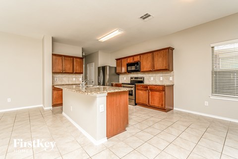 a kitchen with wooden cabinets and a granite counter top