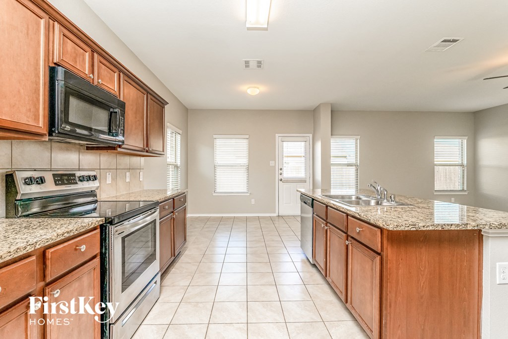 a kitchen with wooden cabinets and stainless steel appliances