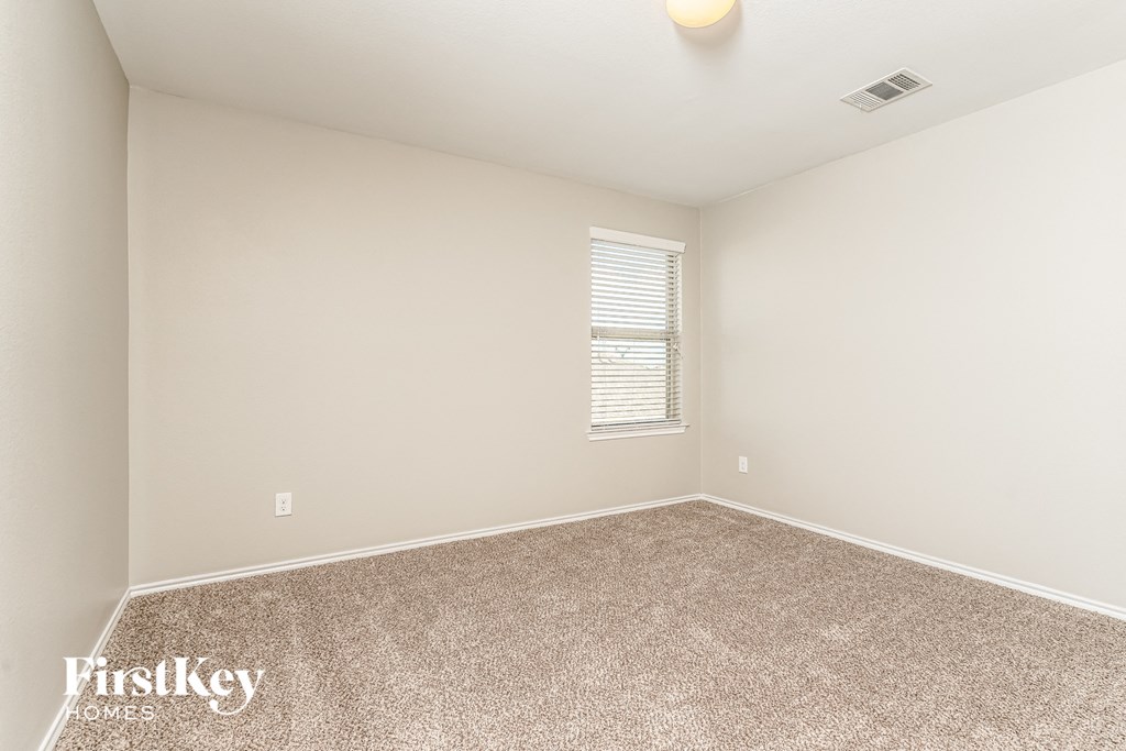 the spacious living room has carpeting and a window