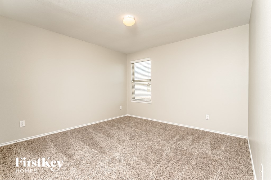 the spacious living room with carpeting and a window