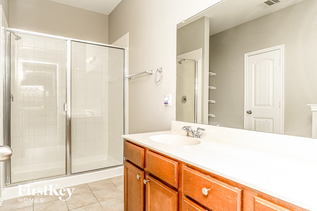 a bathroom with a large mirror and a sink and a shower