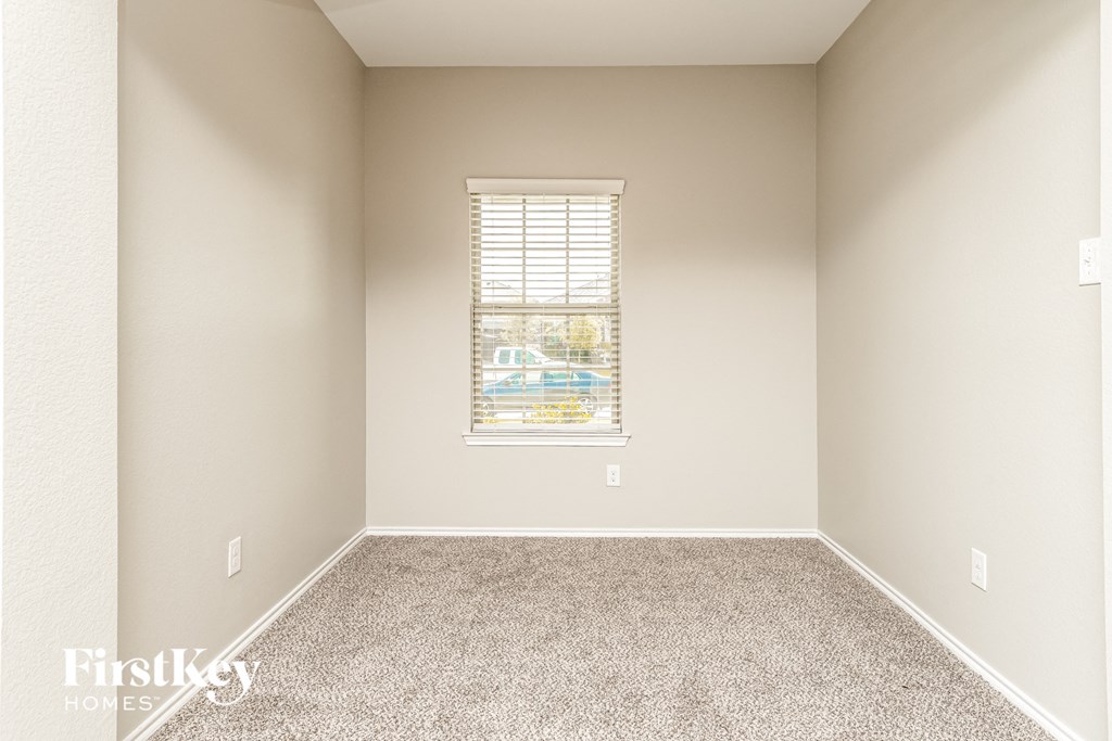 a empty room with carpet and a window