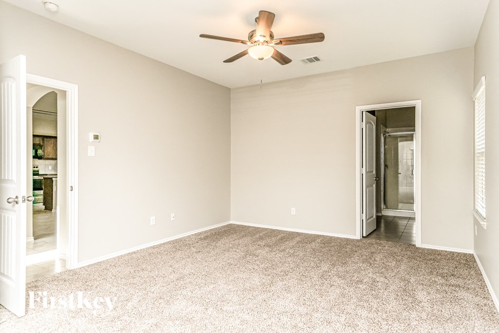 an empty living room with a ceiling fan