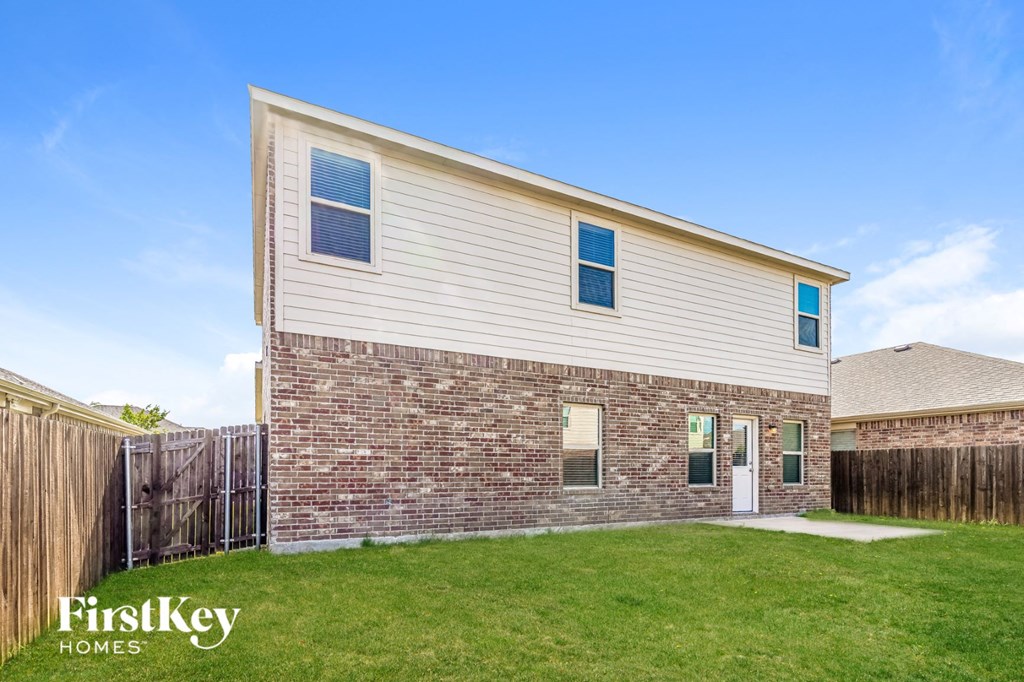 a brick house with a yard and a wooden fence
