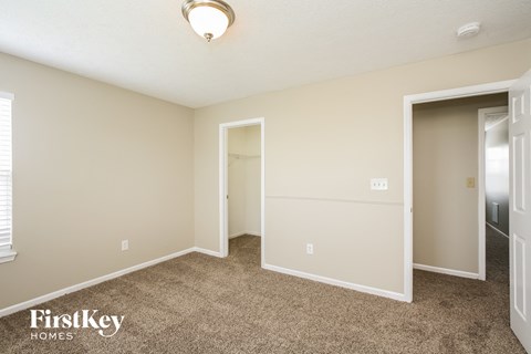 a bedroom with carpet and a door to a closet