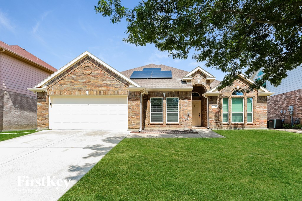 a brick house with a white garage door and a lawn