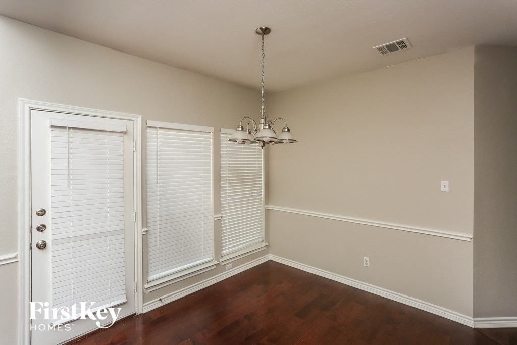 a dining room with a chandelier and a door to a closet