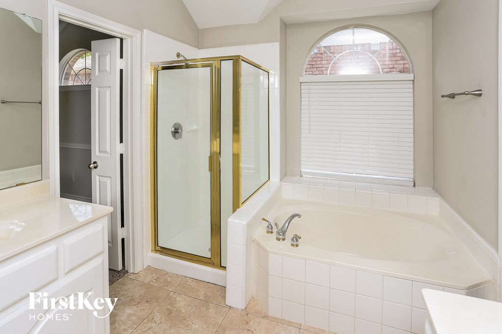 a bathroom with a tub and a shower and a sink
