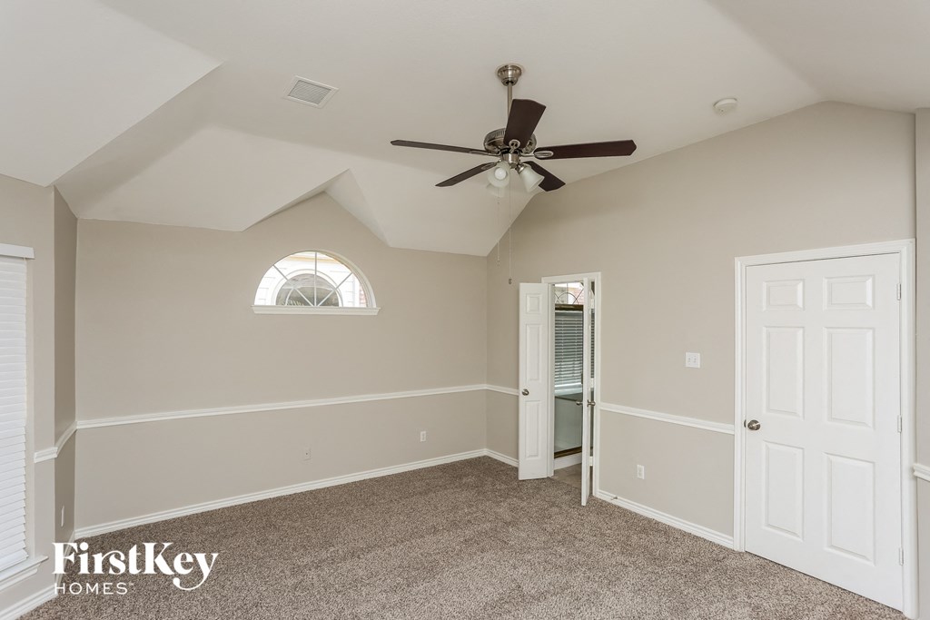 the master bedroom has a ceiling fan and a closet