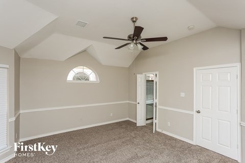 the master bedroom has a ceiling fan and a closet