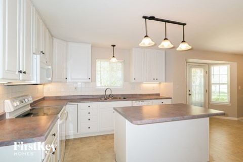 a large kitchen with white cabinets and a counter top