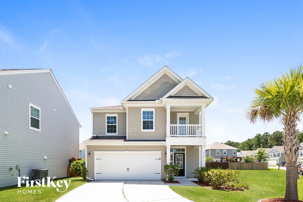 a beige house with a garage and a palm tree