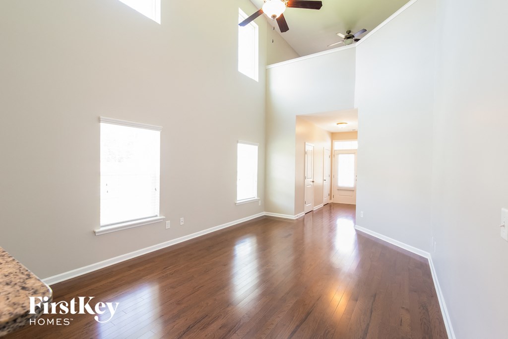 an empty living room with wood floors and white walls