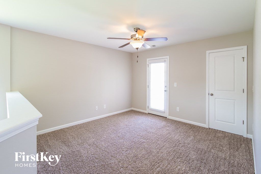 a bedroom with a ceiling fan and a door to a closet