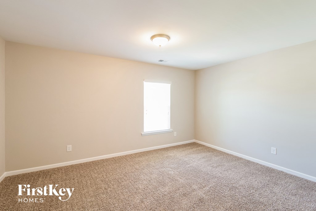 a empty room with carpet and a window