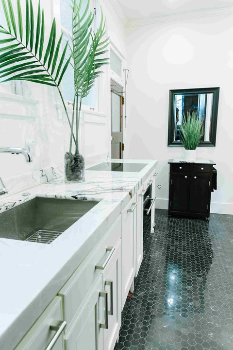 a large white kitchen with a sink and a counter top