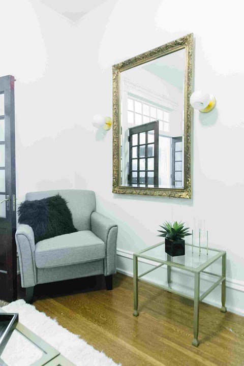 a small living room with a couch and a mirror