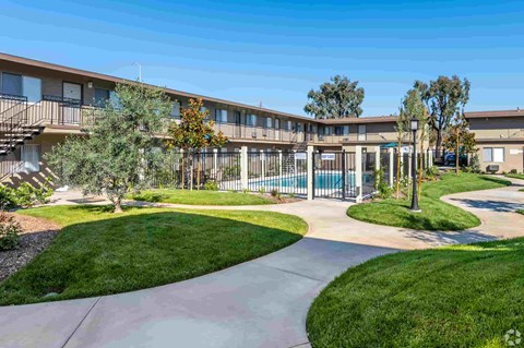 an exterior view of an apartment building with a swimming pool