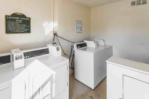 a laundry room with three washers and three washing machines
