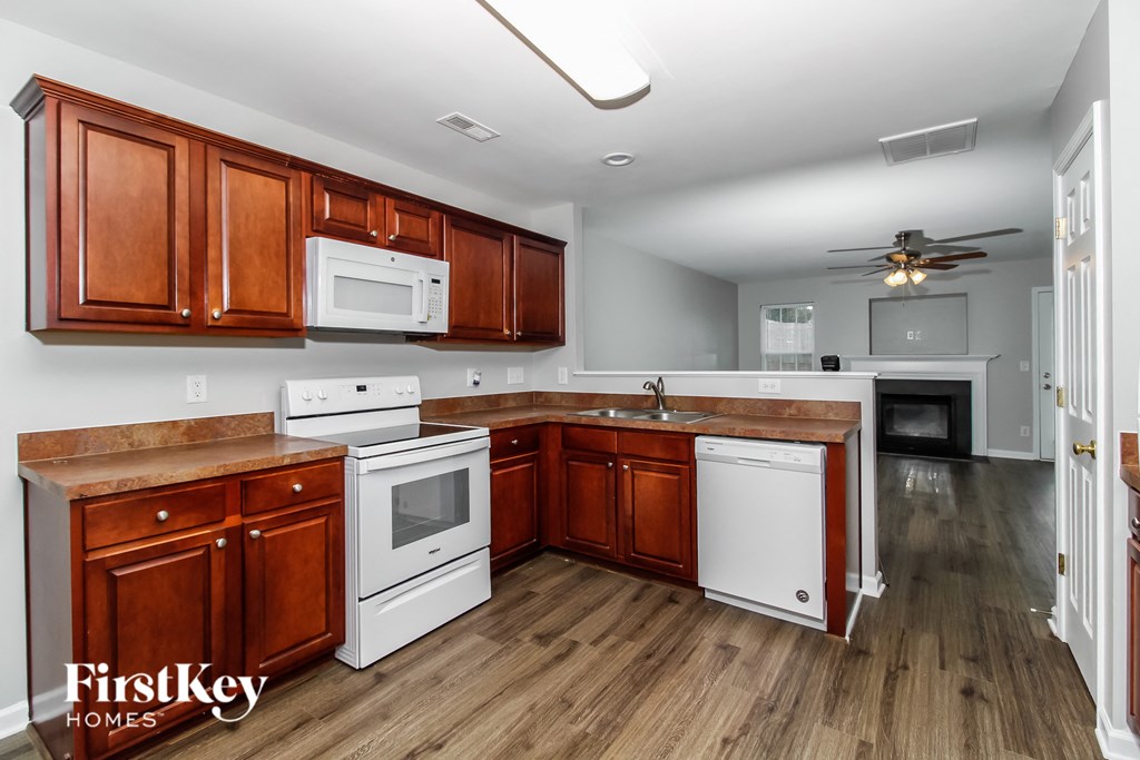 a kitchen with white appliances and wooden cabinets