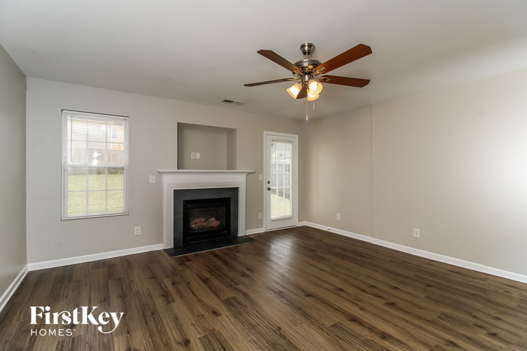 a living room with a fireplace and a ceiling fan