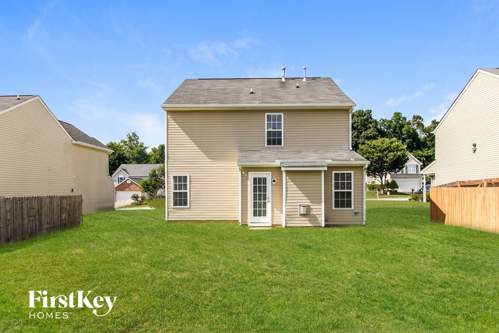 the backyard of a house with a lawn and a fence
