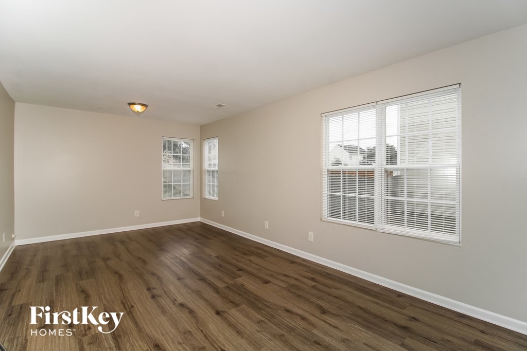 a spacious living room with wood flooring and a large window