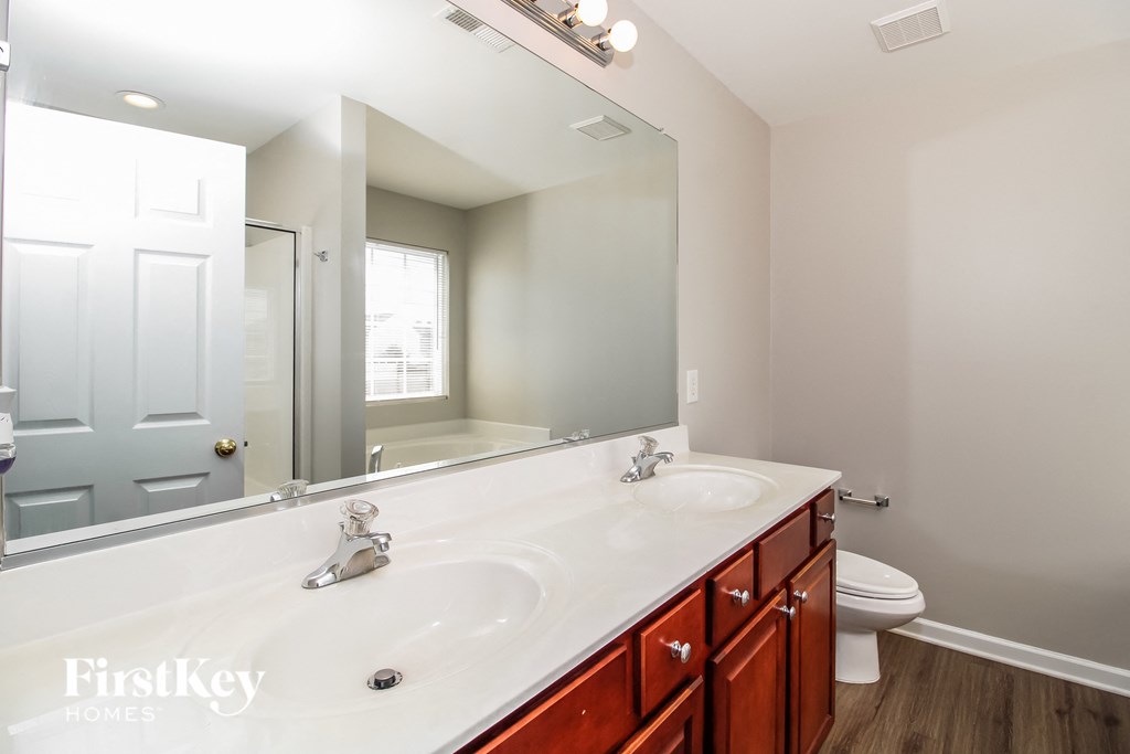 a bathroom with a large mirror and a sink and a toilet