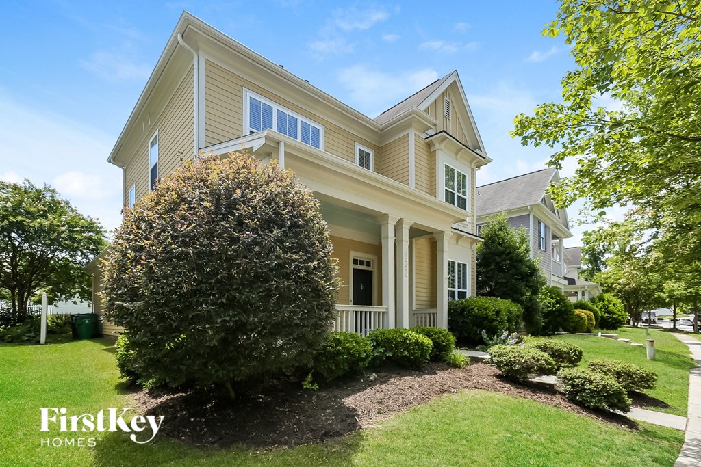 a yellow house with a large tree in front of it